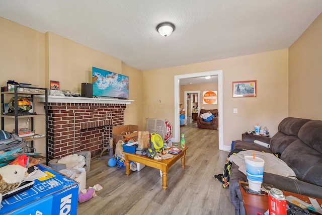 living room with a textured ceiling, light hardwood / wood-style floors, and a fireplace