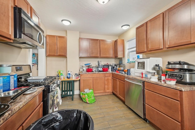 kitchen with light stone counters and appliances with stainless steel finishes