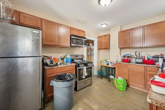 kitchen featuring appliances with stainless steel finishes and light hardwood / wood-style flooring