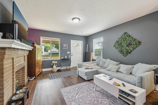 living room featuring a fireplace, a textured ceiling, and dark hardwood / wood-style floors