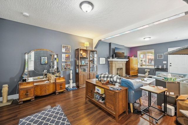 living room featuring a fireplace, dark wood-type flooring, and a textured ceiling