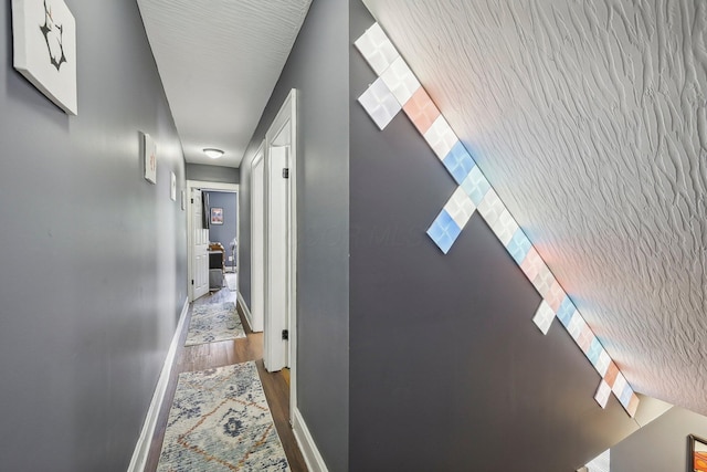 hallway with hardwood / wood-style flooring