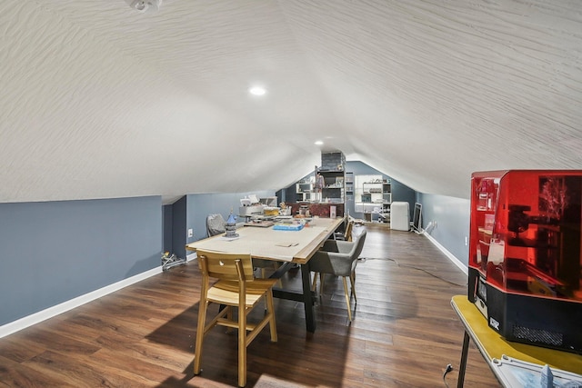 dining space with a textured ceiling, dark wood-type flooring, and lofted ceiling