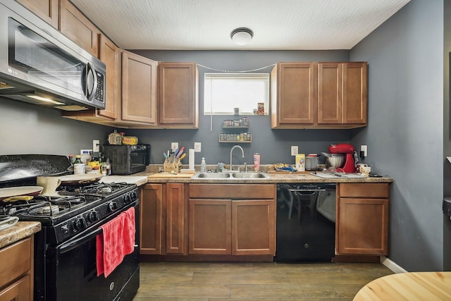 kitchen featuring sink, black appliances, and wood-type flooring