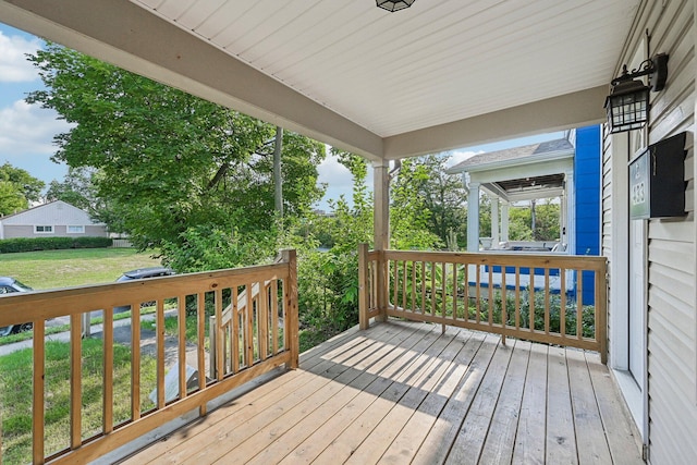 wooden deck featuring a lawn