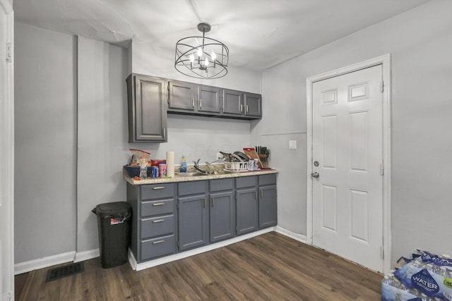 kitchen featuring dark hardwood / wood-style flooring, an inviting chandelier, hanging light fixtures, and gray cabinetry