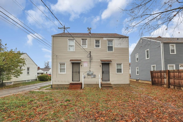 rear view of property featuring a lawn