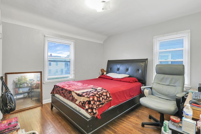 bedroom with dark wood-type flooring and lofted ceiling