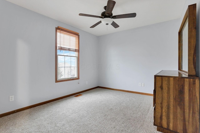 carpeted spare room featuring ceiling fan