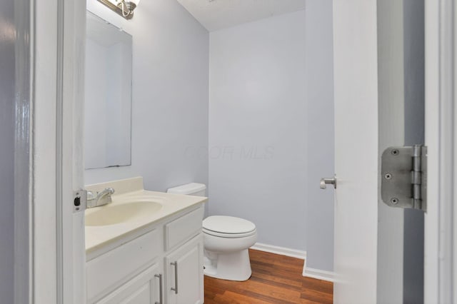 bathroom with vanity, toilet, wood-type flooring, and a textured ceiling