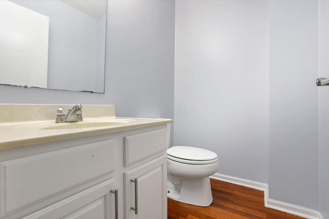 bathroom featuring wood-type flooring, vanity, and toilet