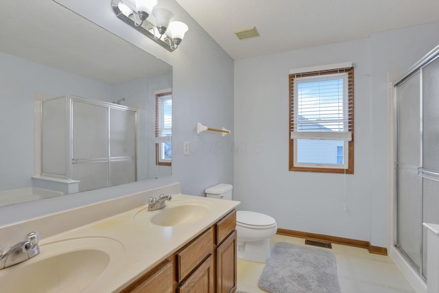 bathroom featuring toilet, vanity, and walk in shower