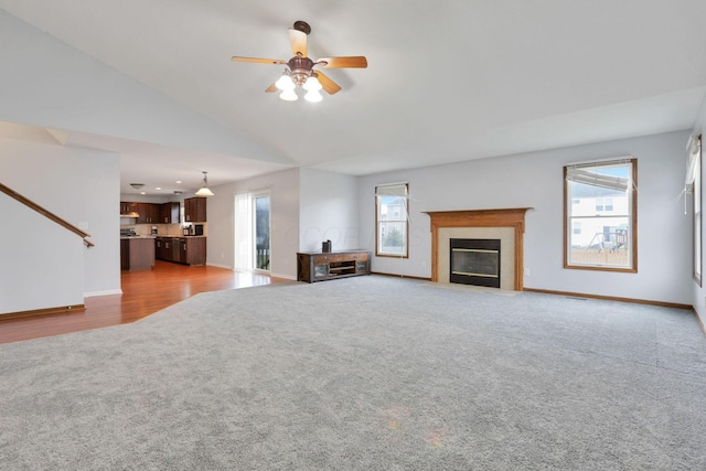 unfurnished living room featuring plenty of natural light, ceiling fan, and carpet floors