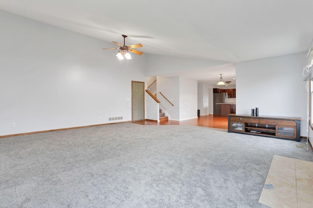 carpeted living room featuring ceiling fan and vaulted ceiling