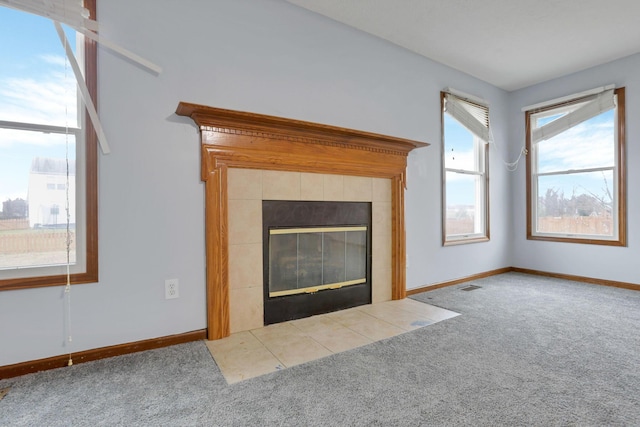 unfurnished living room with a tile fireplace and carpet floors