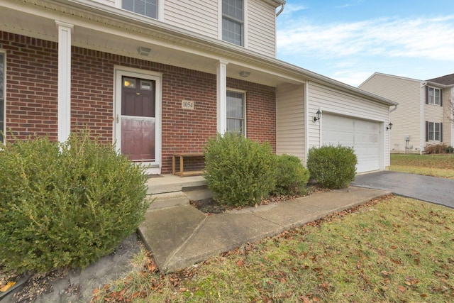 doorway to property featuring a porch and a garage