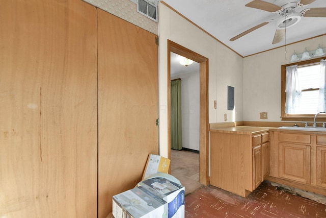 kitchen featuring ceiling fan, electric panel, sink, and light brown cabinetry