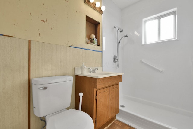 bathroom with vanity, toilet, parquet flooring, and walk in shower