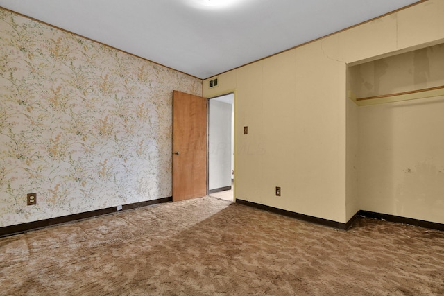 unfurnished bedroom with dark colored carpet and a closet