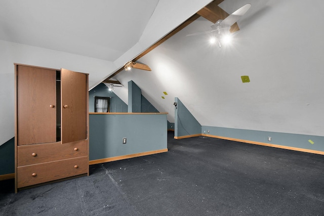 additional living space featuring ceiling fan, lofted ceiling, and dark colored carpet