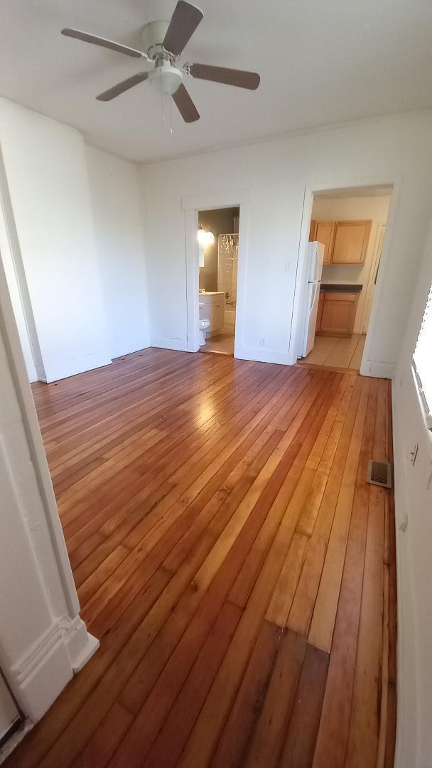 interior space featuring ensuite bath, ceiling fan, white fridge, a walk in closet, and a closet