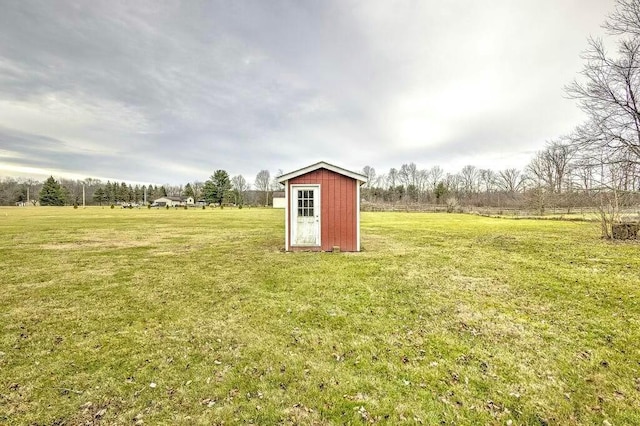 view of yard featuring a rural view and a shed