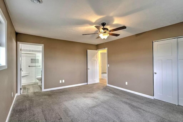 unfurnished bedroom with carpet flooring, ceiling fan, and ensuite bath