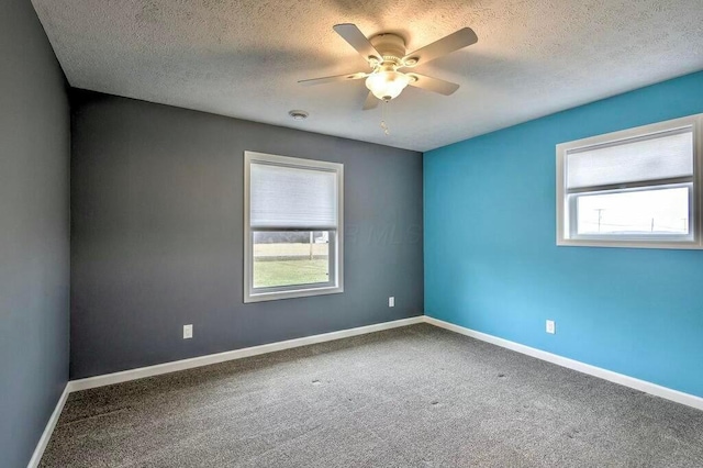 carpeted empty room with a textured ceiling and ceiling fan