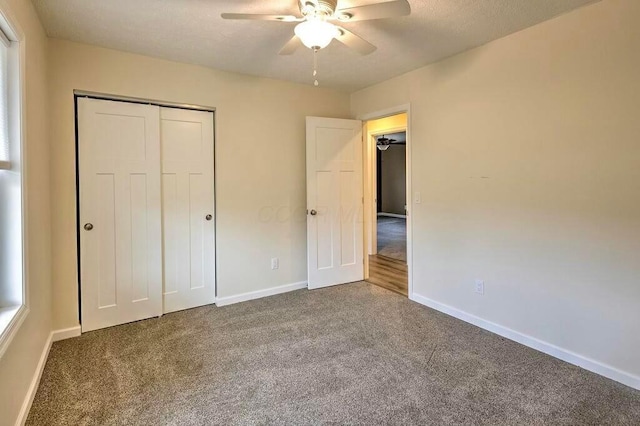 unfurnished bedroom with ceiling fan, carpet floors, and a closet