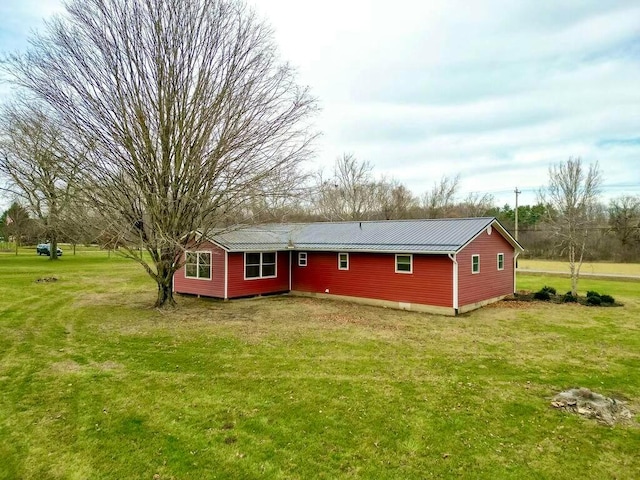 rear view of house featuring a yard