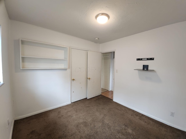 unfurnished bedroom featuring carpet and baseboards