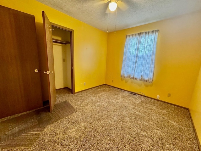 unfurnished bedroom with ceiling fan, carpet flooring, and a textured ceiling