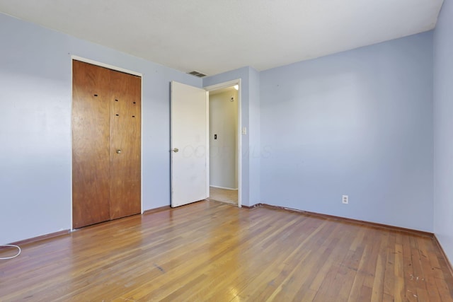 unfurnished bedroom with light hardwood / wood-style floors and a closet