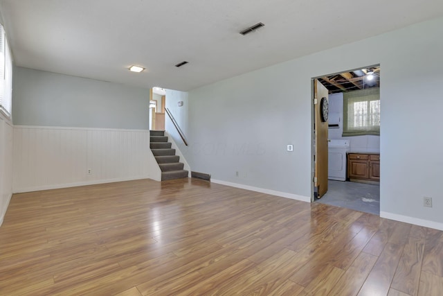 spare room with washer / dryer and light hardwood / wood-style flooring