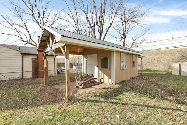 exterior space with cooling unit, an outbuilding, and a front lawn