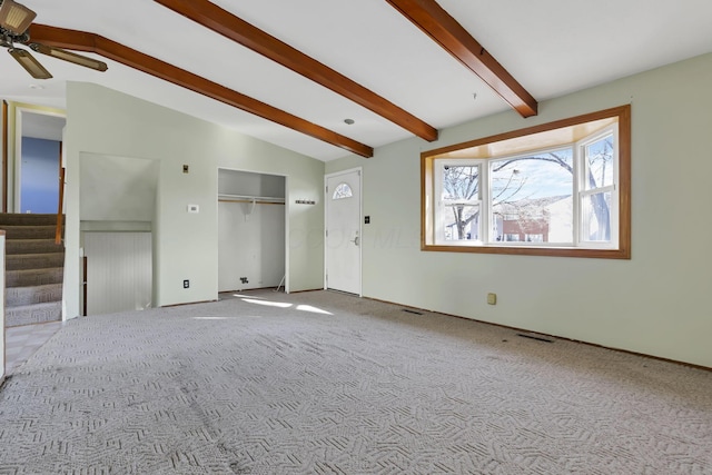 interior space featuring vaulted ceiling with beams, ceiling fan, and light colored carpet