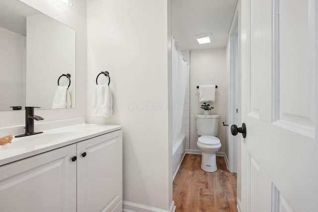 full bathroom featuring hardwood / wood-style floors, vanity, shower / bath combination with curtain, and toilet