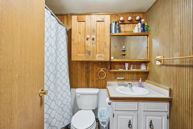 bathroom featuring wood walls, vanity, and toilet