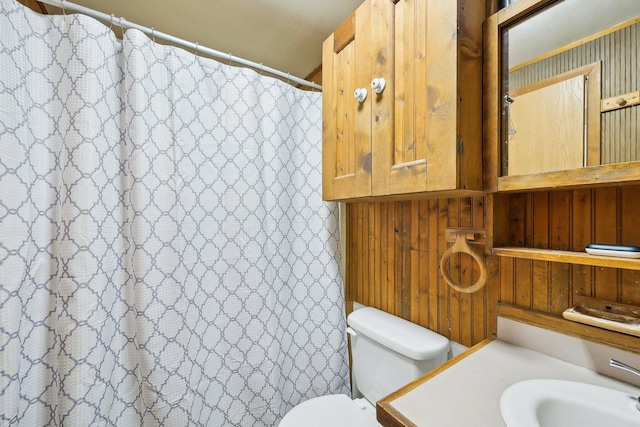 bathroom featuring a shower with curtain, toilet, and vanity