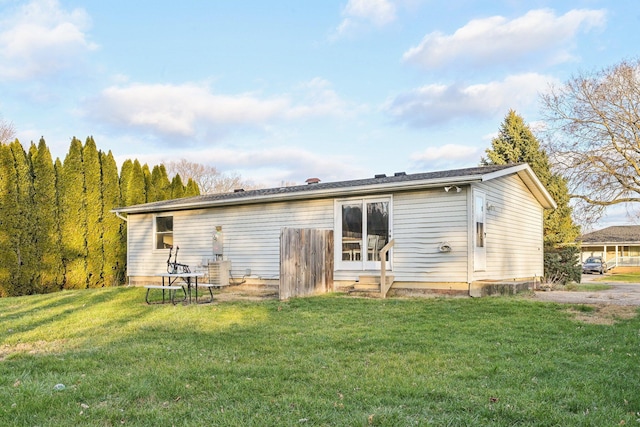 back of house featuring a lawn and central AC