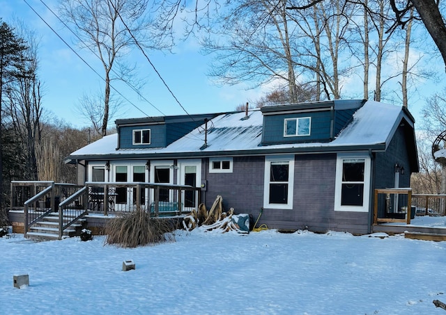 snow covered property with a deck