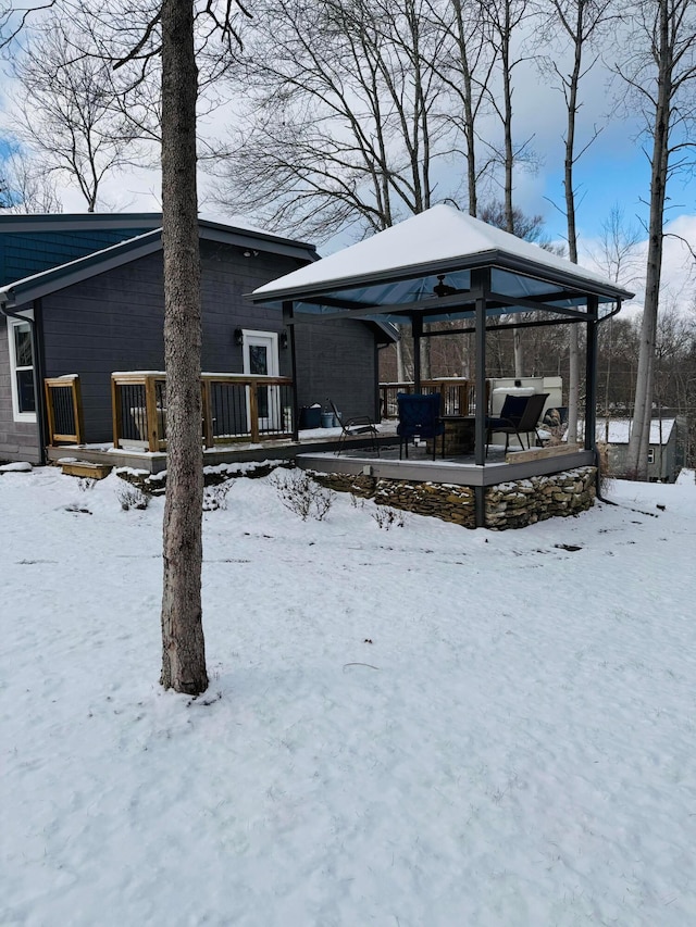 snow covered house with a gazebo and a deck