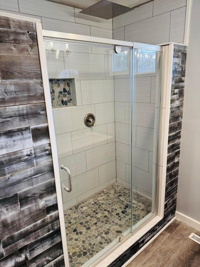 bathroom with wood-type flooring and an enclosed shower