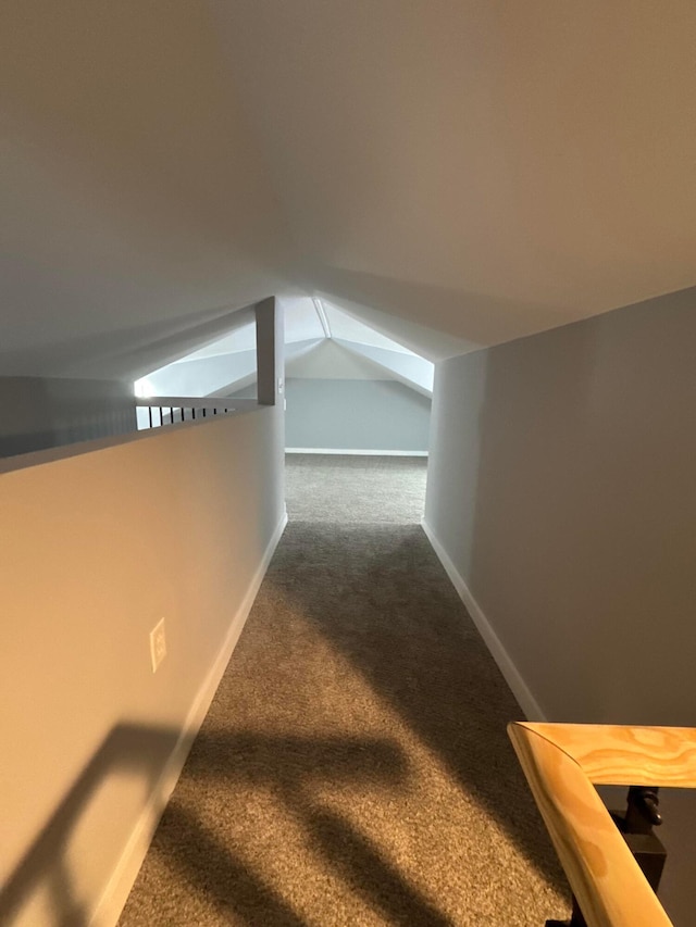 corridor featuring vaulted ceiling and carpet floors