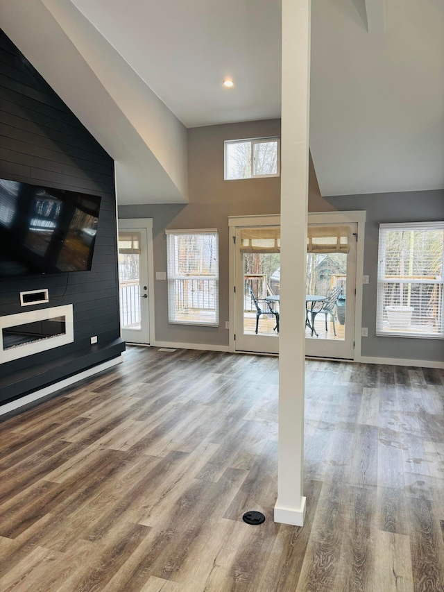 interior space with plenty of natural light, a large fireplace, and hardwood / wood-style floors