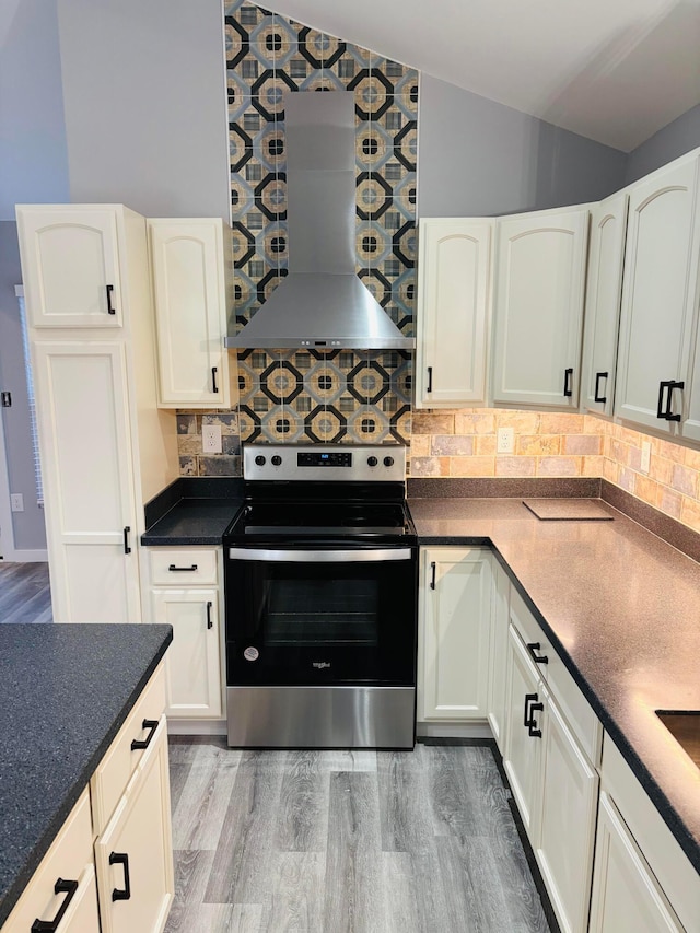 kitchen featuring stainless steel range with electric stovetop, ventilation hood, white cabinets, hardwood / wood-style flooring, and backsplash