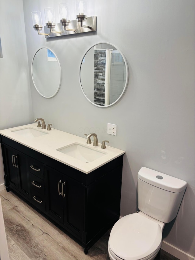 bathroom with vanity, toilet, and hardwood / wood-style floors