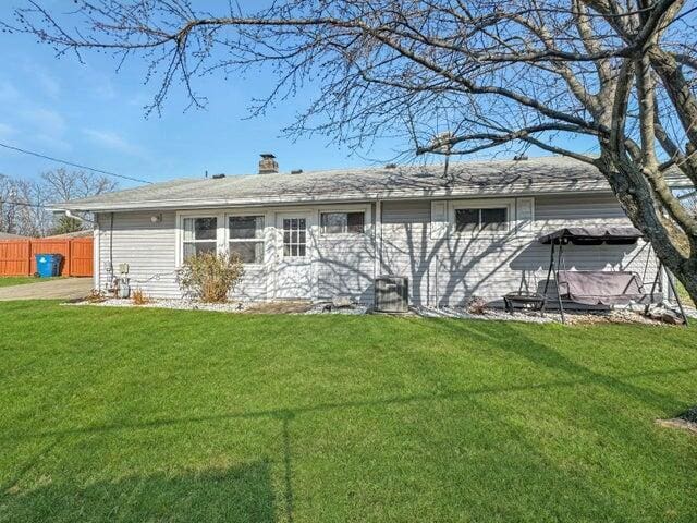 rear view of property featuring a yard