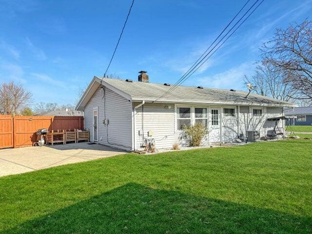 back of property featuring a patio, central AC, and a lawn