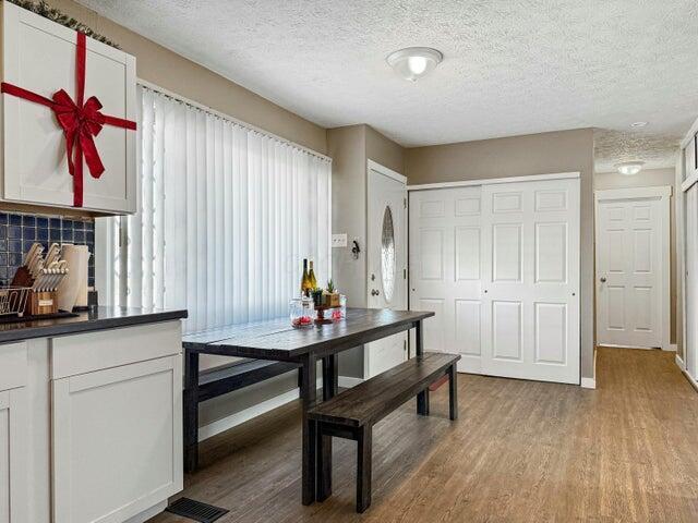 dining space with light hardwood / wood-style floors and a textured ceiling